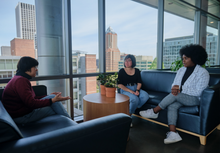 A group of people meet in the lobby of the School of Social Work