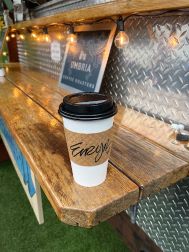 Coffee cup sitting on a shelf with the name Eiryn written on the cuff.
