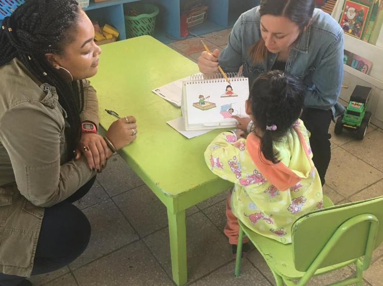 Two student clinicians working with a young child