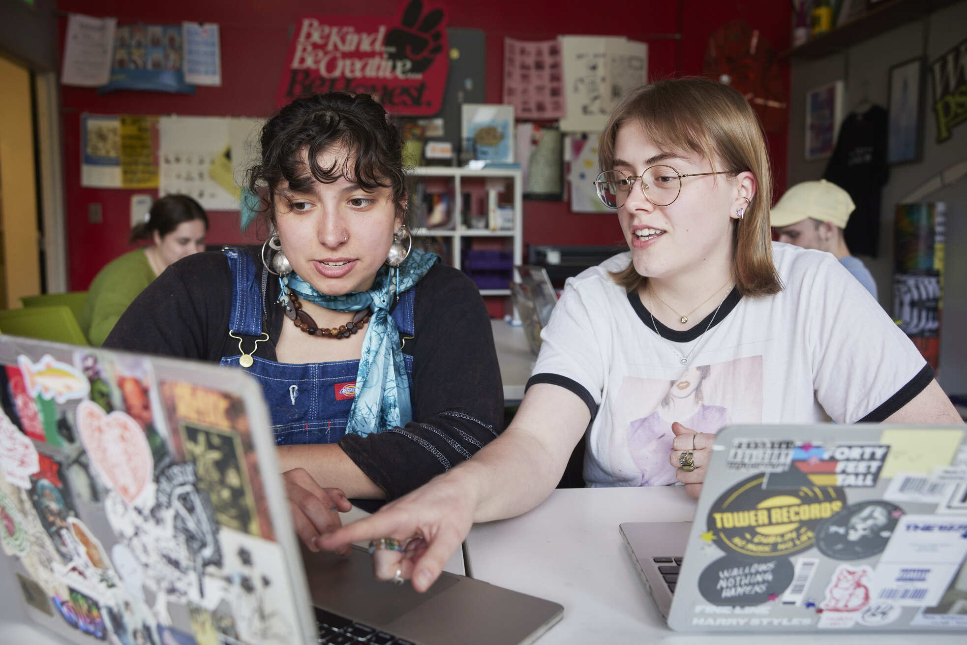Two students, each with a laptop, collaborating.