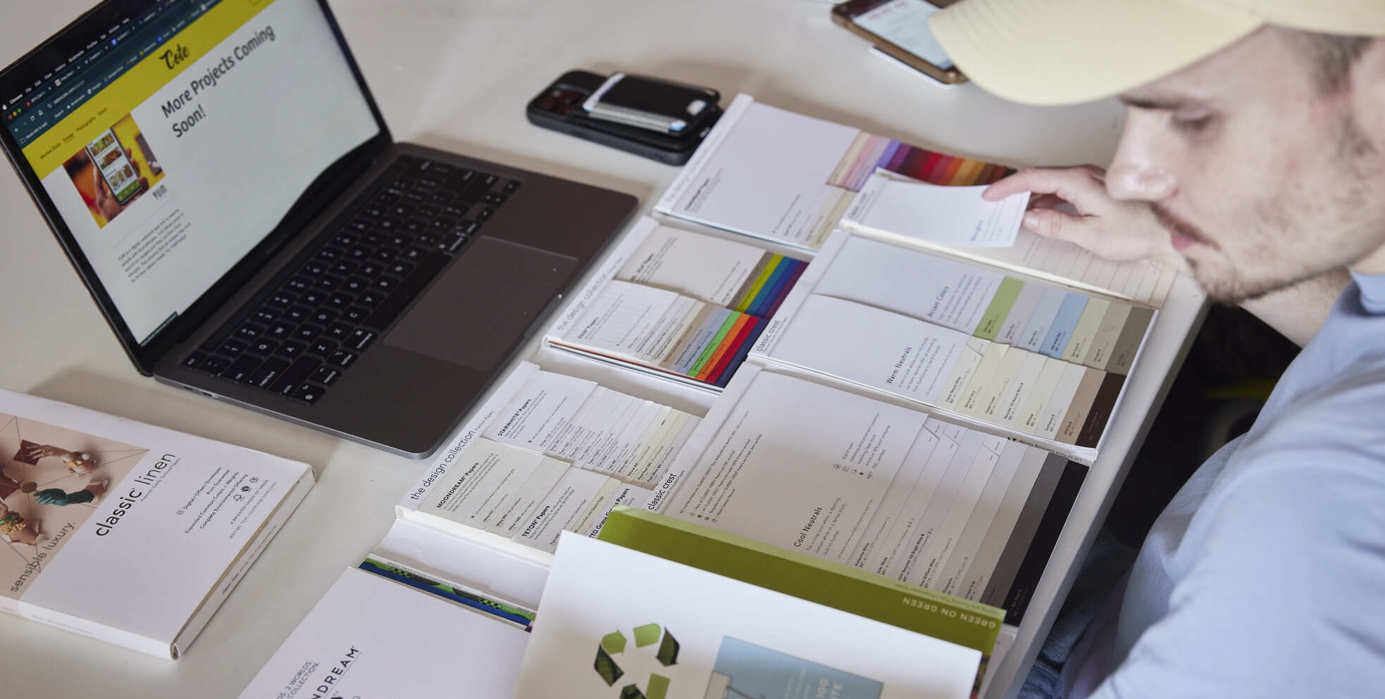 Young person with a laptop and an array of study materials.