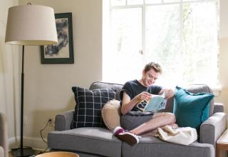 Resident sitting on couch, reading