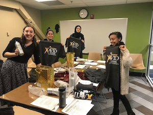 AVID volunteers holding up AVID T-shirts