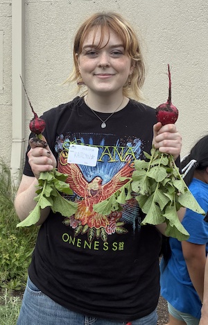Mentor Kaitlyn Graves holds up two radishes