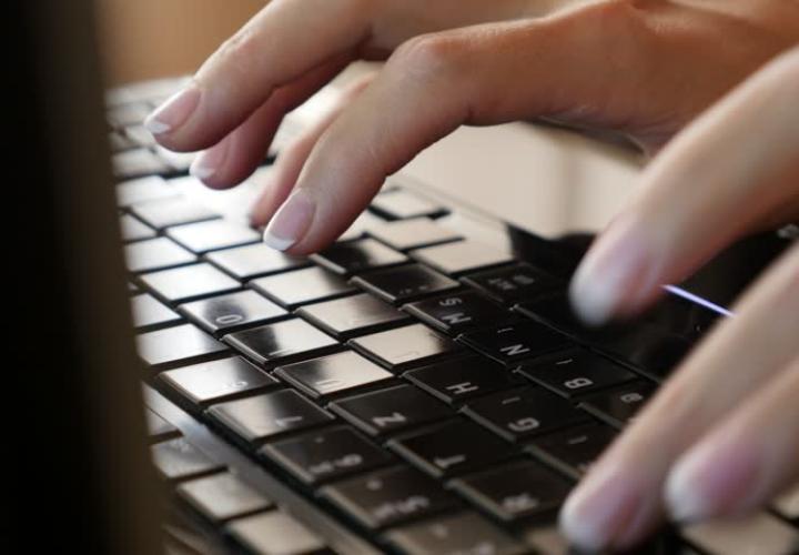 Hands typing on a laptop