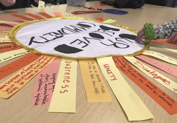 A paper sun reads "Our Beloved Community" and includes message from students written on each ray of the sun about what "Our Beloved Community" means to them