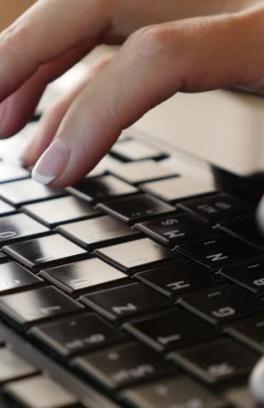 Hands typing on a laptop