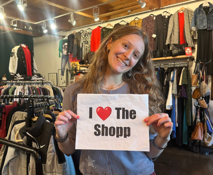 Girl holding a paper saying I love the shop