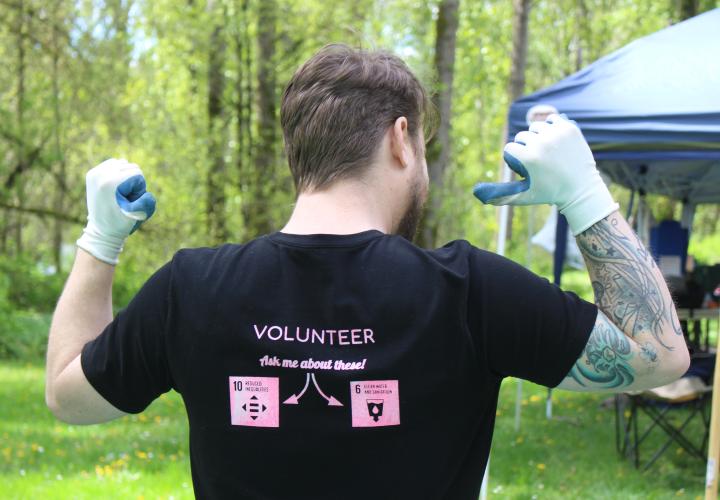 Man pointing to the back of his shirt that reads VOLUNTEER