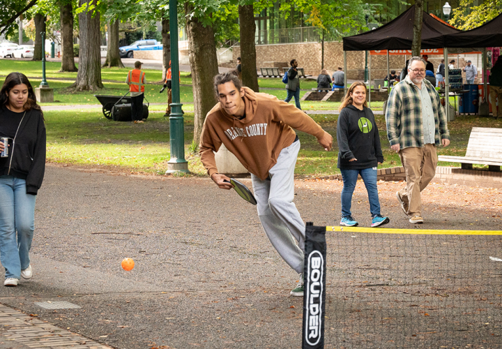 A student playing pickleball at Party in the Park