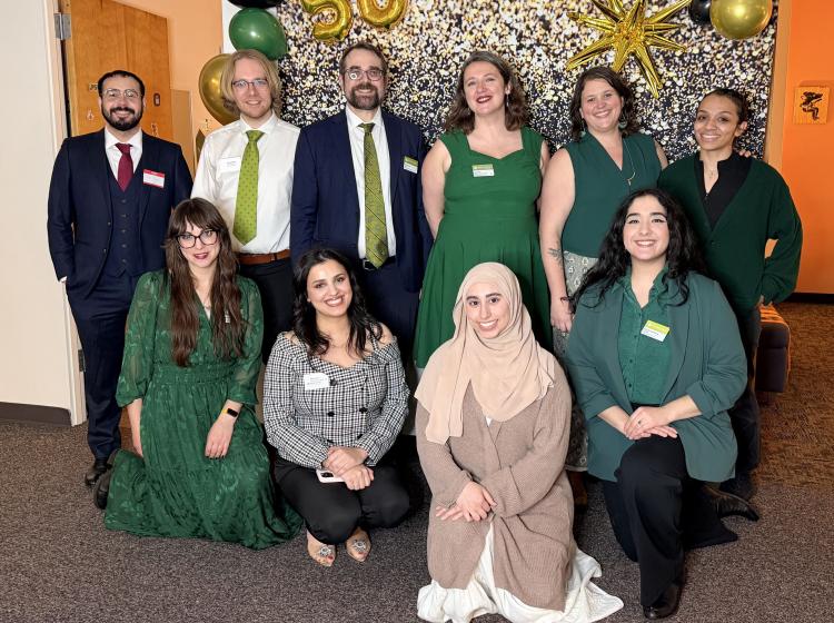 sls team members pose in front of 50 banner