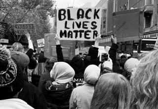 protestors march with Black Lives Matter sign