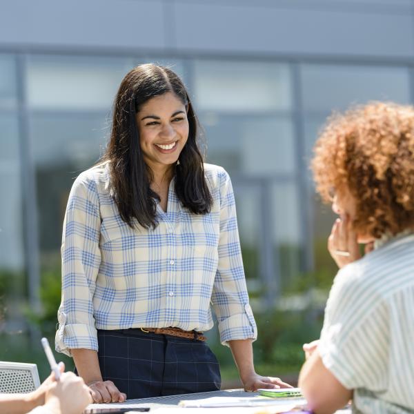 Female student outside address other students.