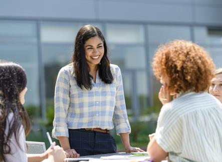 Female student outside address other students.