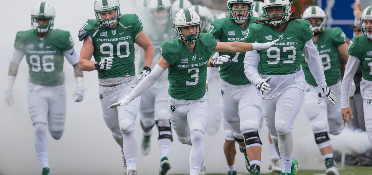 Portland State football team running out onto the football field.