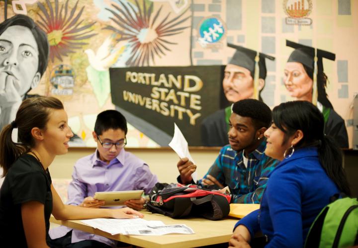 Group of students sitting around a table talking.