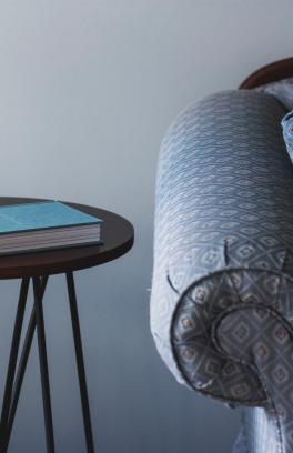 Blue couch with a side table and notebook.