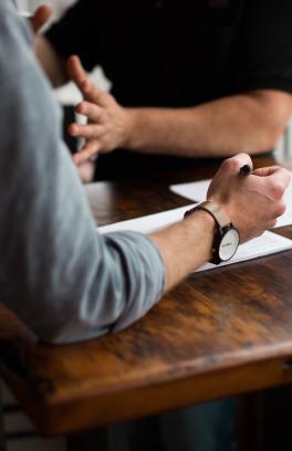 Person at a table writing on paper.