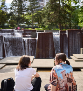 Students sitting outside at fountain