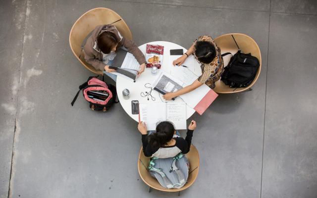 arial view of 3 students around a table studying