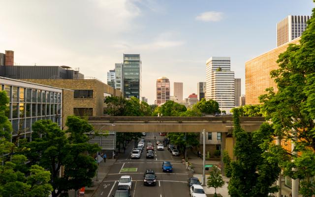 Cars, skybridge and city buildings in backdrop