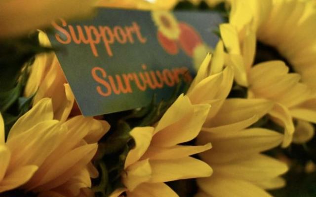 sign that reads "support survivors" surrounded by flowers