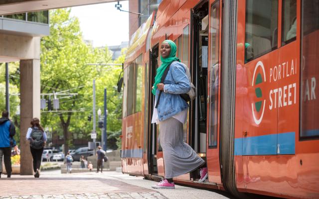 woman stepping off the Portland streetcar