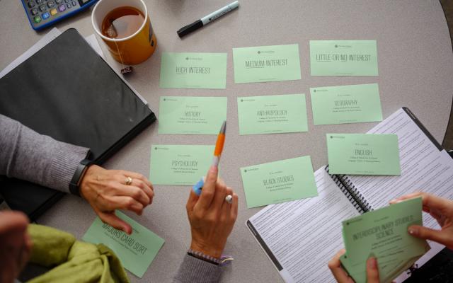 person gesturing at notecards with PSU majors listed on them