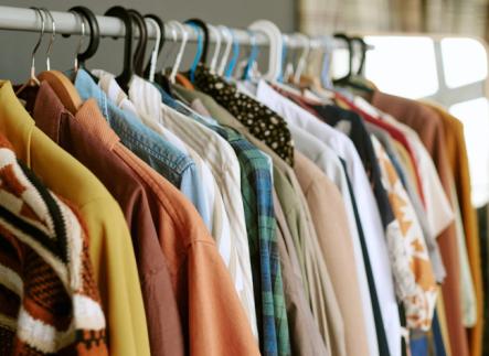 a clothing rack of multicolored shirts hanging on hangers 