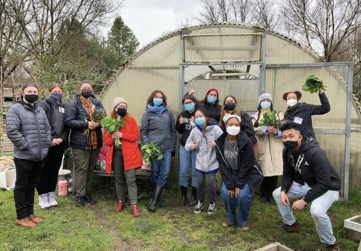 Students posing in front a greenhouse