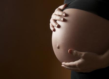image of pregnant person with hands around their belly 