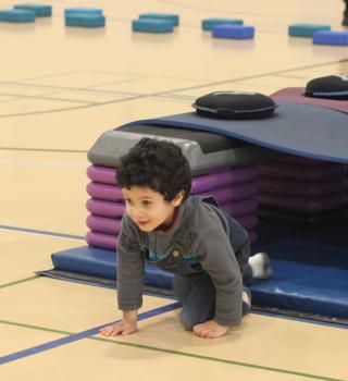 Kid crawling on gym floor