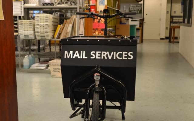 Bike with storage container labeled mail services