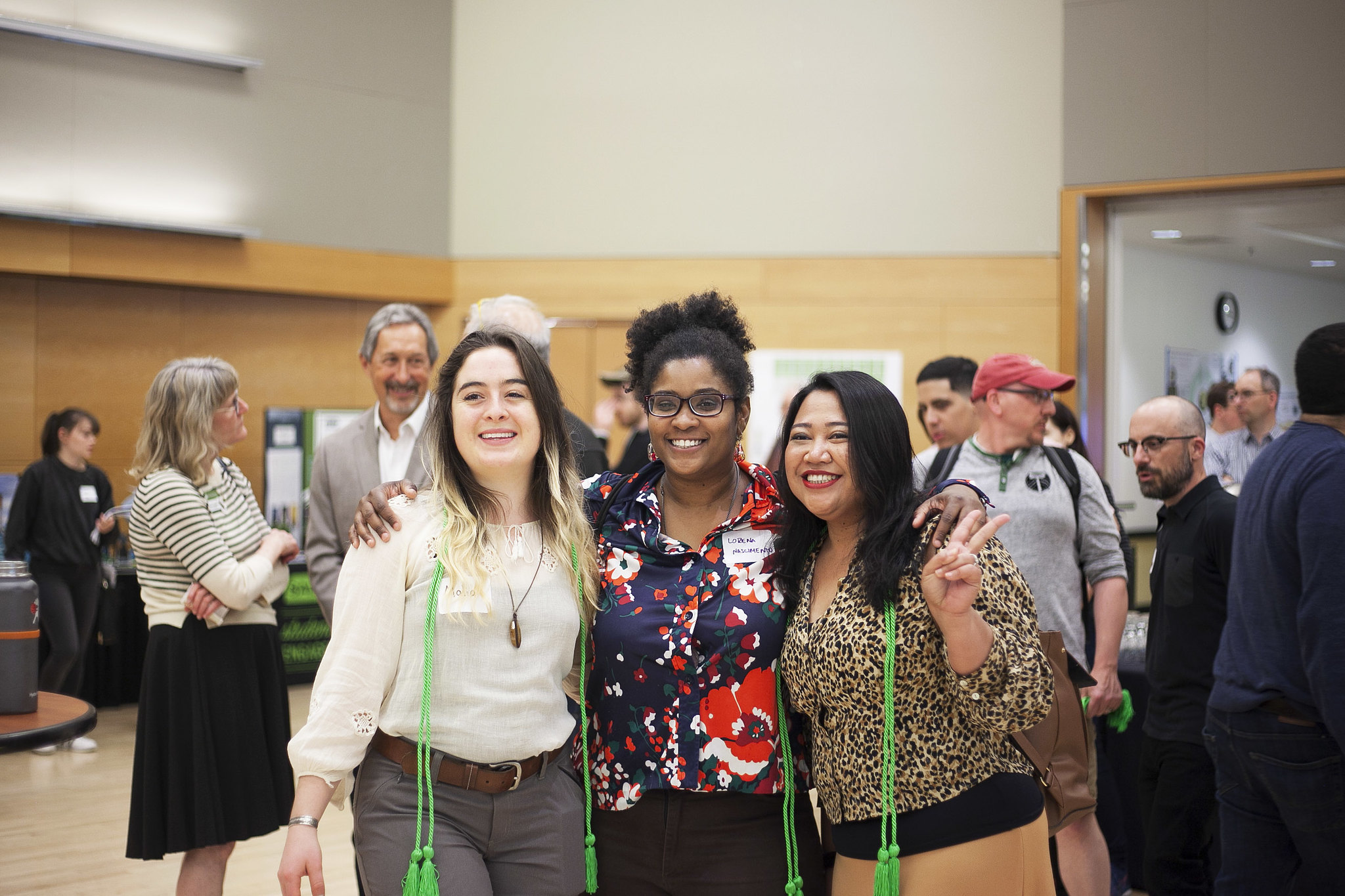 three students with green graduation cords