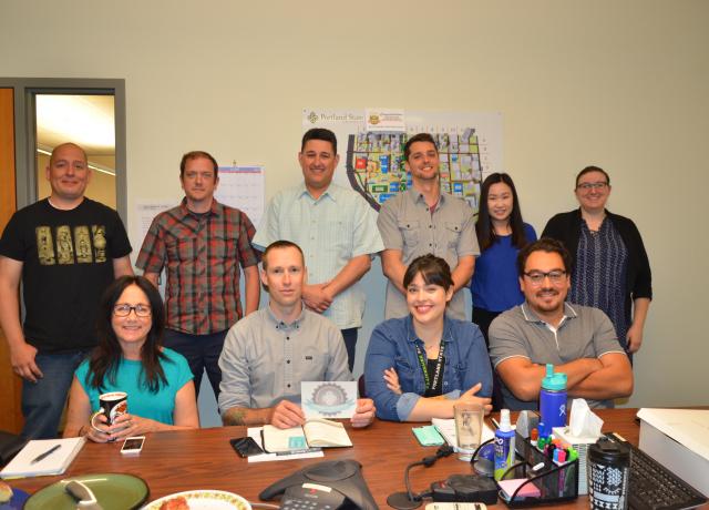 Ten people in a conference room with one person holding climate champions badge