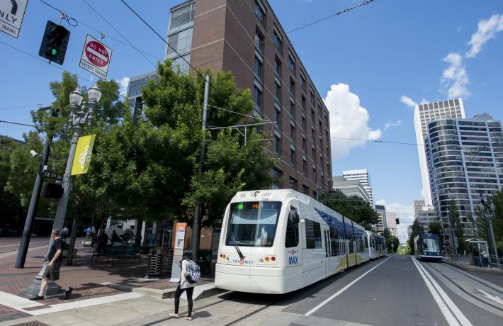 Person crossing in front of stopped Max train