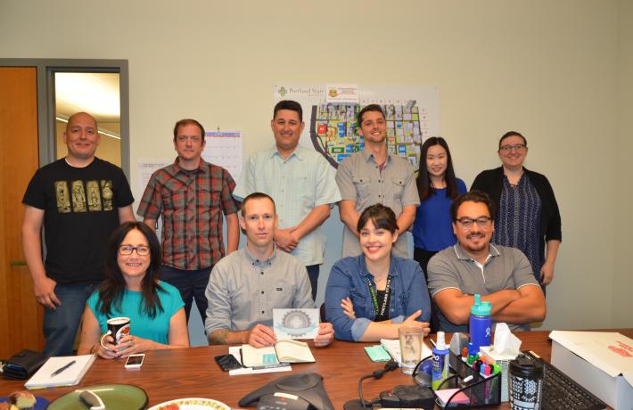 Ten people in a conference room with one person holding climate champions badge