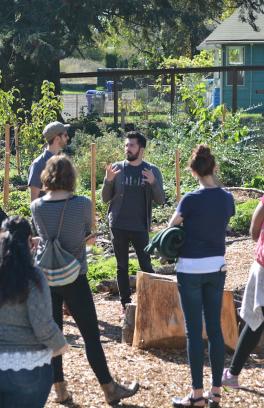 A group of people gather around a person speaking during a floodplains tour in SE Portland