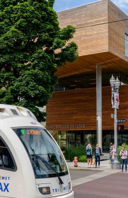 A MAX train crosses in front of the Karl Miller Center