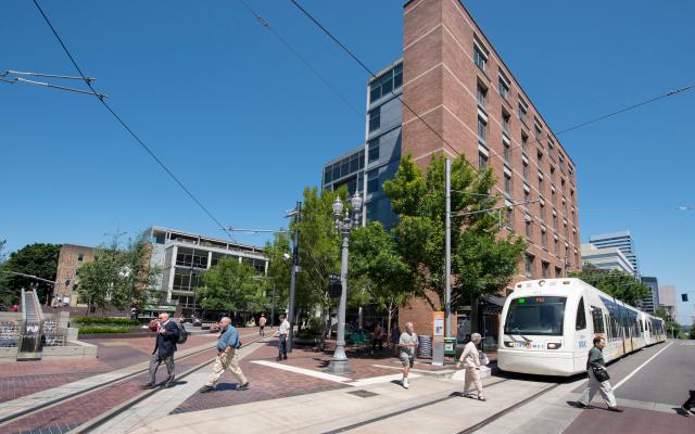 people crossing in front of the max train on southwest 5th avenue