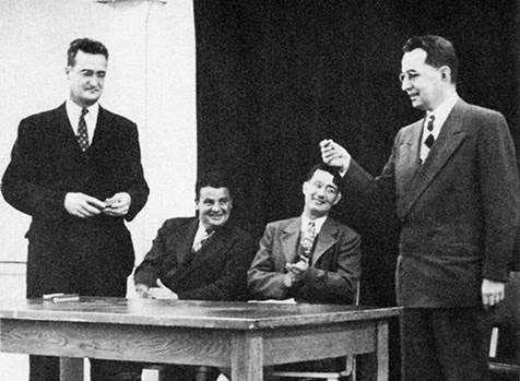 State Representative Rudie Wilhelm receives a commemorative pen from Stephen Epler (left) for co-sponsoring the bill that moved the extension center to the Park Blocks in downtown Portland. Joe Holland, faculty member and athletic director, and Phil Putnam, Vanport Center's assistant director, applaud