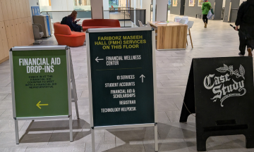 Directional signage guiding students to Portland State University’s Financial Wellness Center in FMH