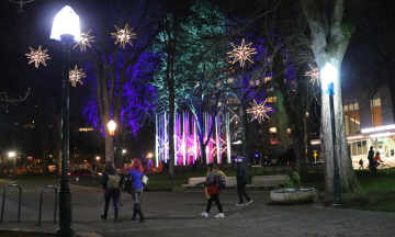 Students walking in PSU park blocks under hanging light installations
