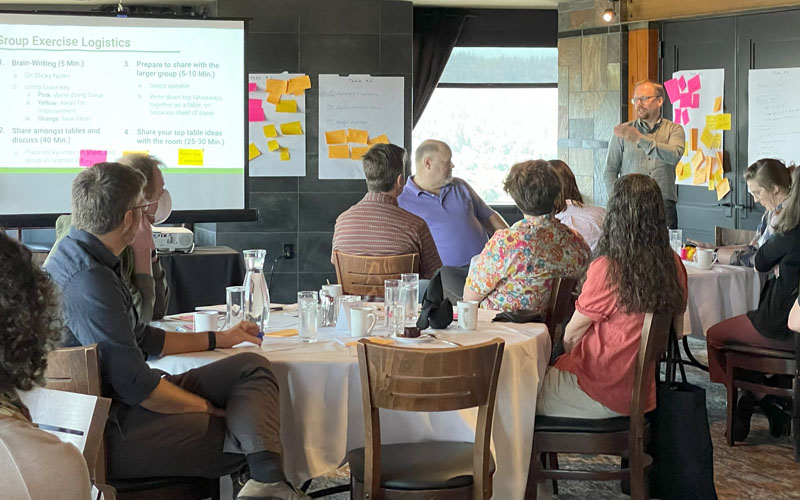 OIT staff in a conference room conversing with posters and post-its on the walls