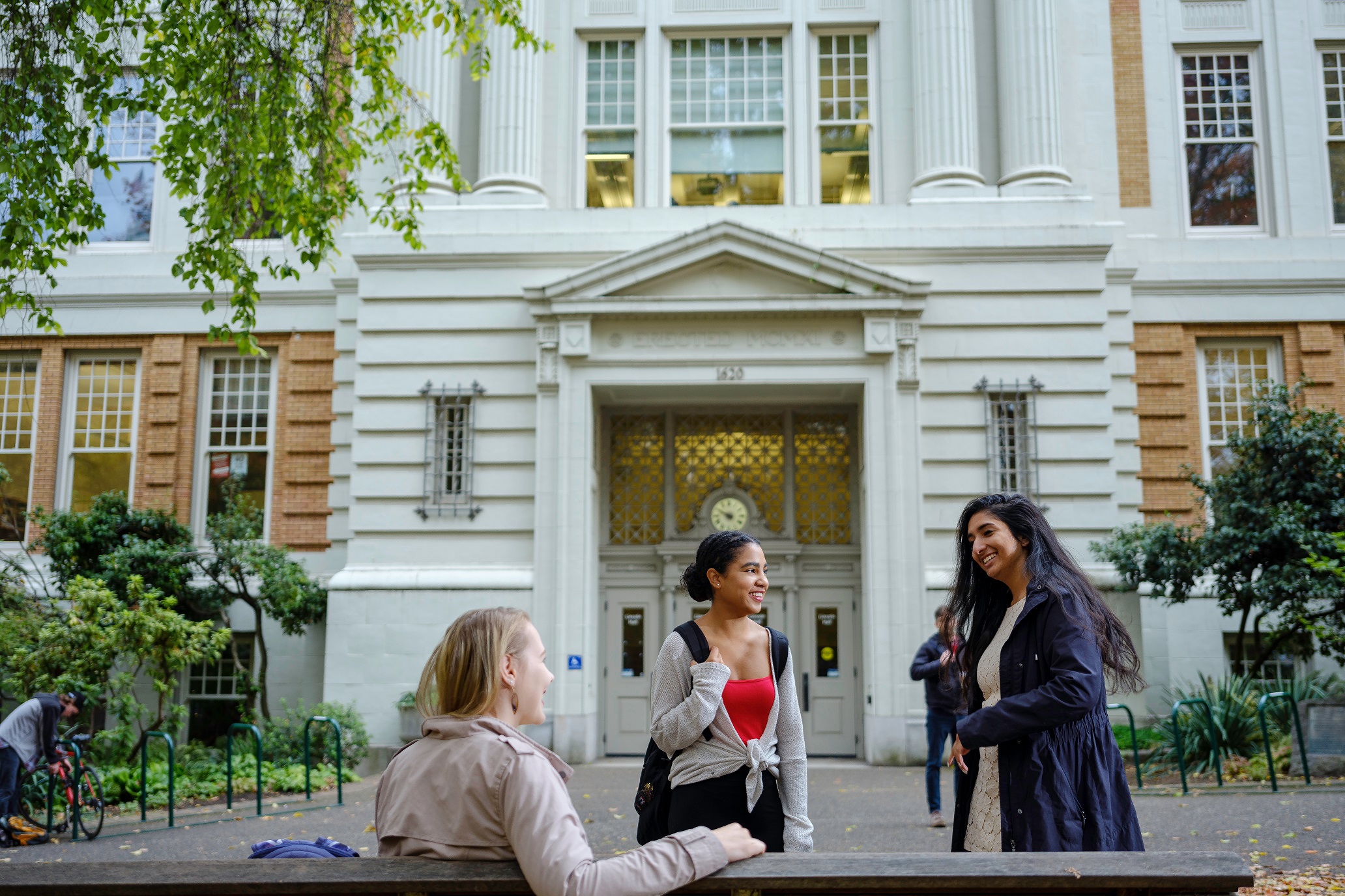 Three students on the park blocks conversing