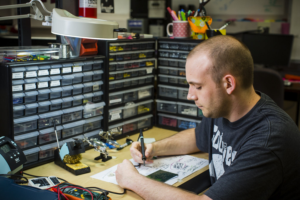 Person sitting at a desk with tools working