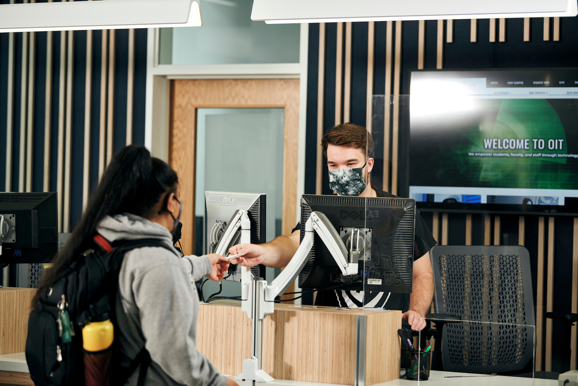 Student in mask at Student Services desk in FMH building