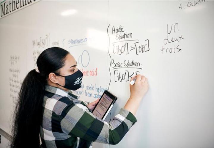 Student writing on whiteboard