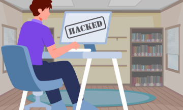 Image depicts someone sitting at their computer, the screen displays text that says hacked