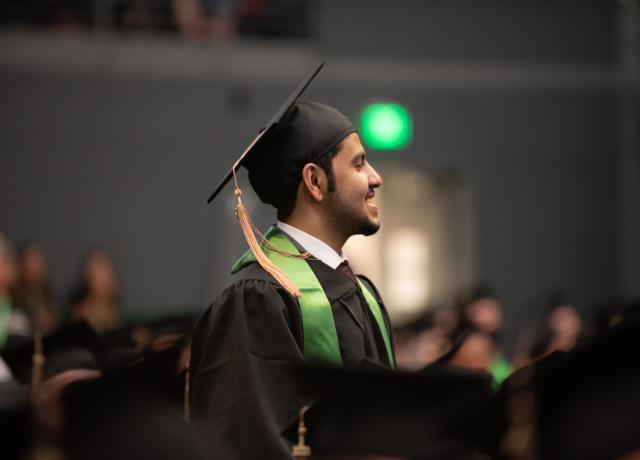 Student in graduation cap smiling.